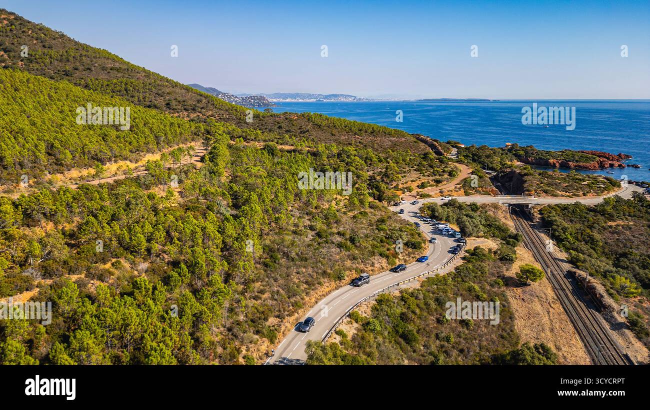 Vista aerea panoramica della costa dei monti Esterel con tortuose strade costiere e binari ferroviari che sovrastano il Mar Mediterraneo, la Costa Azzurra e il Sud Foto Stock
