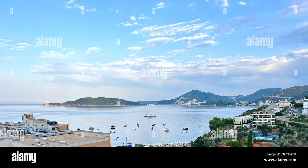 Vista sul mare Adriatico con barche ormeggiate, montagne in lontananza e moderni edifici sul mare sotto un cielo azzurro, perfetti per viaggi e stile di vita. - Immagine stock catturata con smartphone