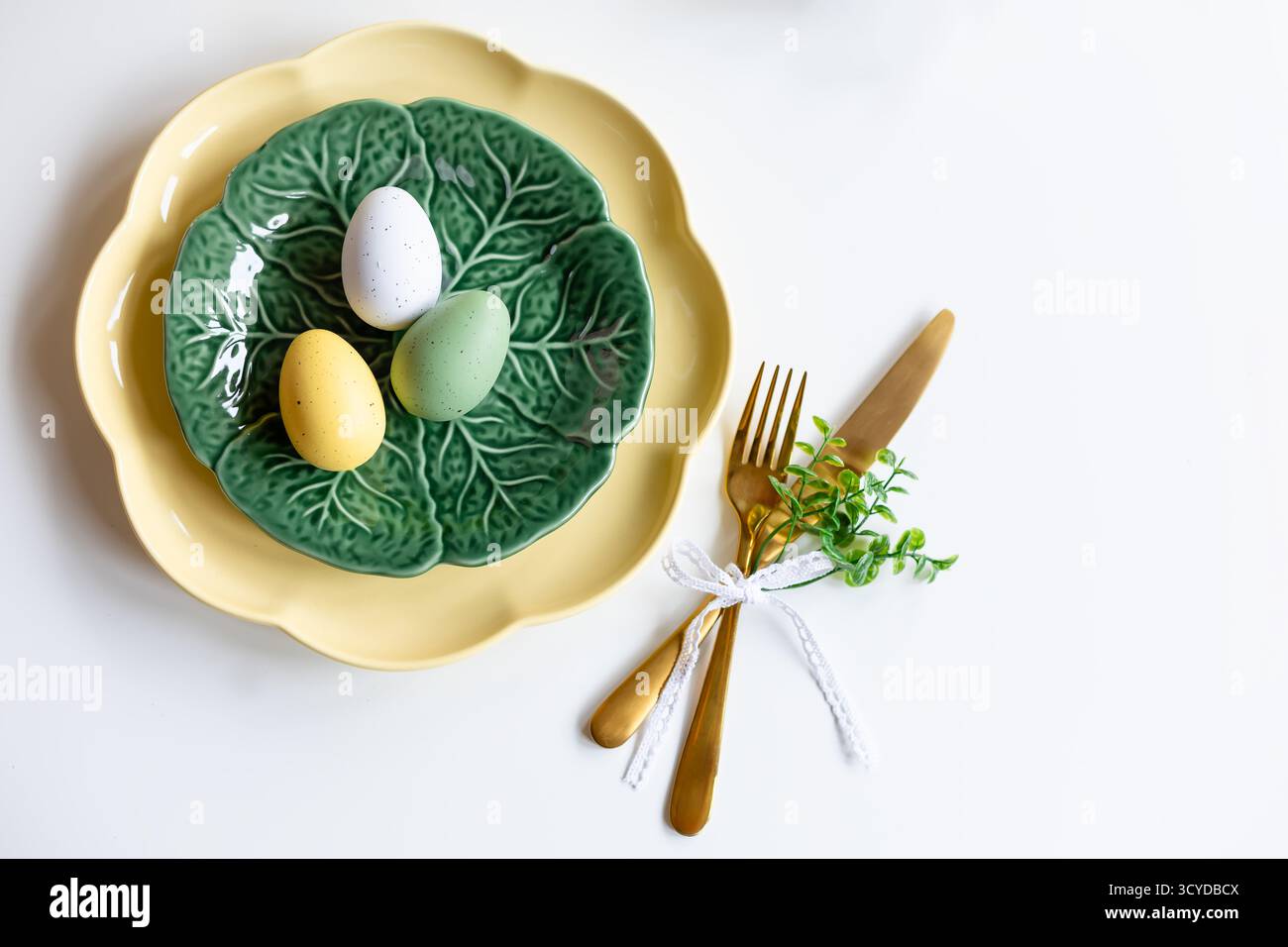 Buona Pasqua. Concetto di festa di Pasqua. Vista dall'alto piatto verde e giallo vuoto, uova di Pasqua, su sfondo bianco isolato. Copia spazio, posiziona Foto Stock