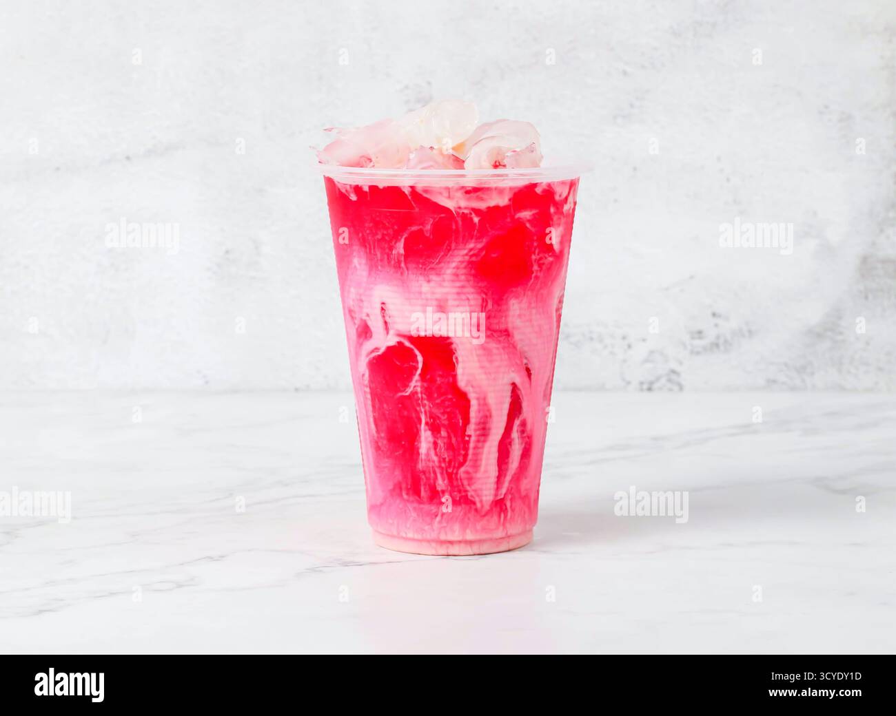 bandung drink o Ice Rose Milk Tea con cubetti di ghiaccio serviti in una tazza di plastica isolata sullo sfondo in marmo vista laterale della bevanda di Singapore Foto Stock