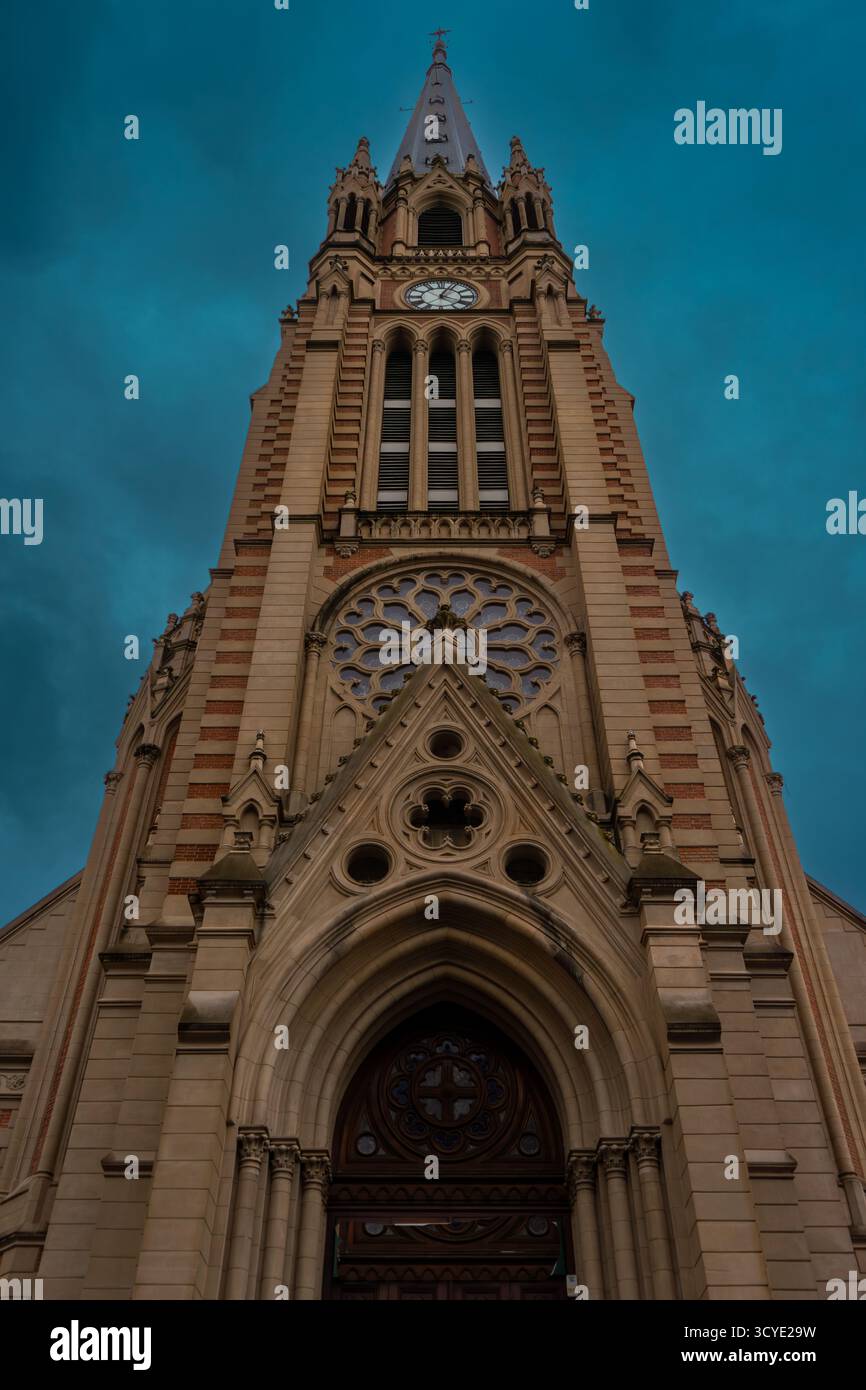 Vista laterale della guglia della chiesa sotto le spettacolari nuvole Foto Stock
