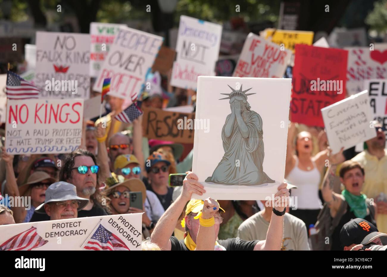 Austin Texas USA, 18 ottobre 2025: Migliaia di manifestanti marciano lungo Congress Avenue durante la manifestazione di protesta "No Kings" contro l'amministrazione del presidente Donald Trump. Greg Abbott, capo del Texas, ha minacciato un lancio della Guardia Nazionale del Texas contro quella che era una protesta ampiamente pacifica monitorata dalla polizia locale. Crediti: Bob Daemmrich/Alamy Live News Foto Stock