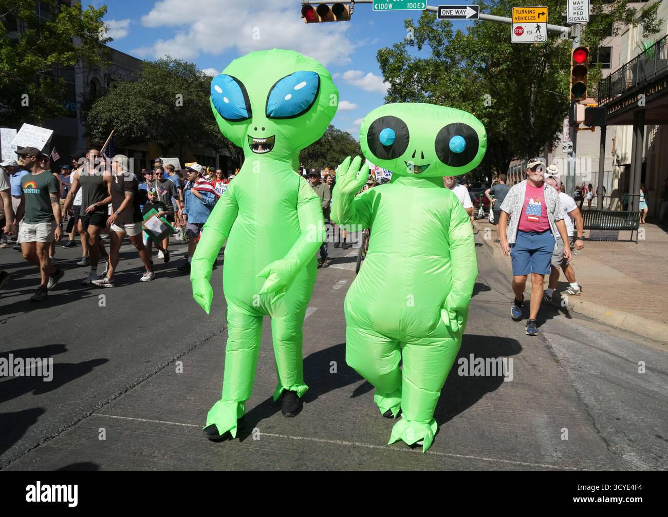 Austin Texas USA, 18 ottobre 2025: Due persone vestite con costumi alieni spaziali si uniscono alle migliaia di manifestanti che marciano lungo Congress Avenue durante una manifestazione di protesta "No Kings" contro l'amministrazione del presidente Donald Trump. Greg Abbott, governatore del Texas, ha minacciato un lancio della Guardia Nazionale del Texas contro quello che era un evento ampiamente pacifico monitorato dalla polizia locale. Crediti: Bob Daemmrich/Alamy Live News Foto Stock