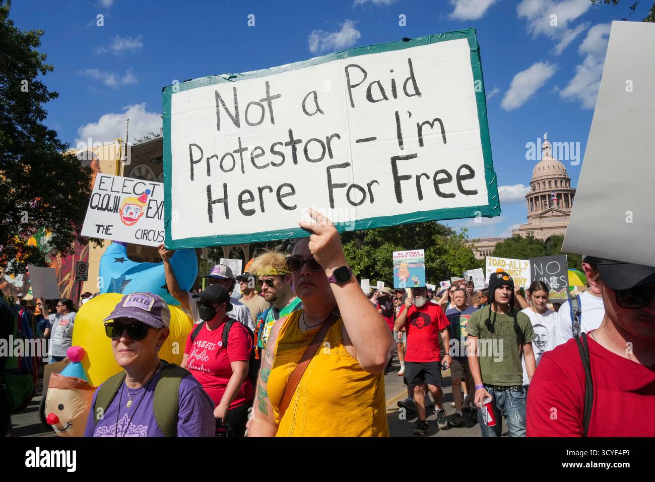 Austin Texas USA, 18 ottobre 2025: Migliaia di manifestanti marciano lungo Congress Avenue durante la manifestazione di protesta "No Kings" contro l'amministrazione del presidente Donald Trump. Greg Abbott, capo del Texas, ha minacciato un lancio della Guardia Nazionale del Texas contro quella che era una protesta ampiamente pacifica monitorata dalla polizia locale. Crediti: Bob Daemmrich/Alamy Live News Foto Stock