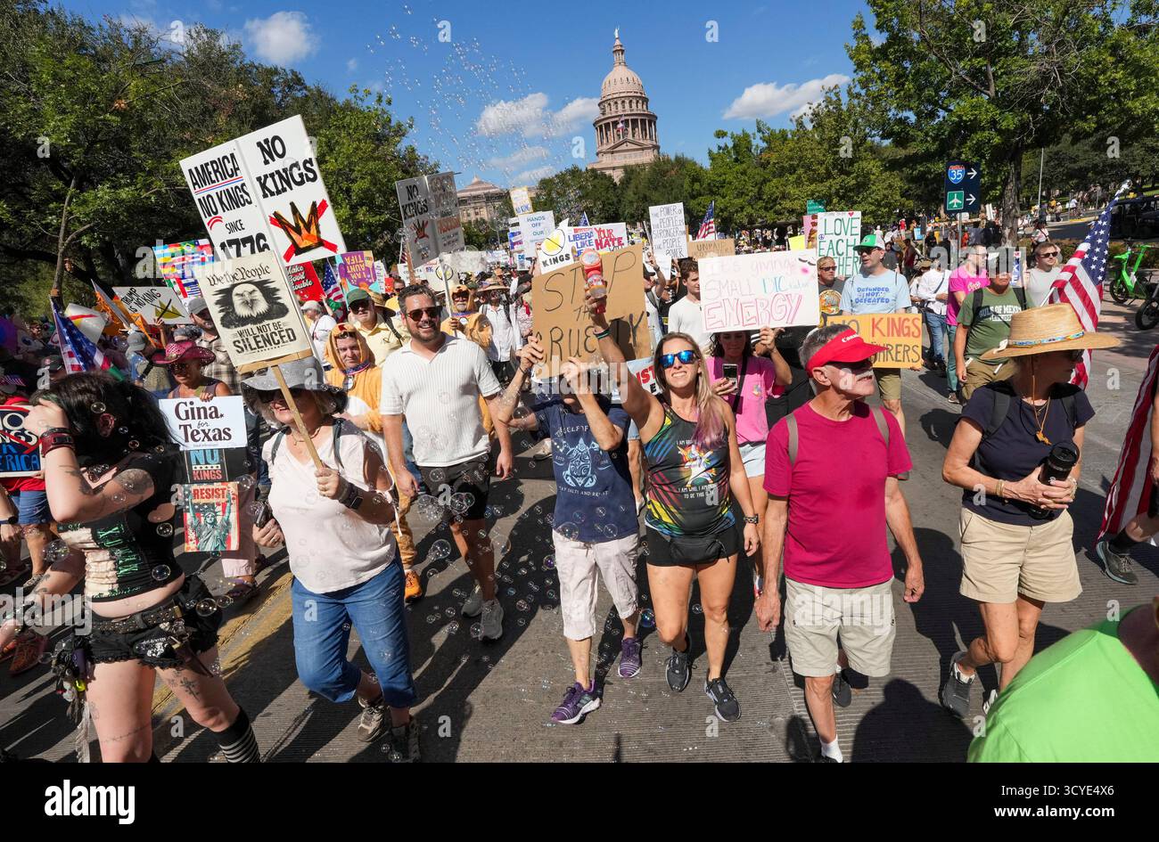 Austin Texas USA, 18 ottobre 2025: Migliaia di manifestanti marciano lungo Congress Avenue durante la manifestazione di protesta "No Kings" contro l'amministrazione del presidente Donald Trump. Greg Abbott, capo del Texas, ha minacciato un lancio della Guardia Nazionale del Texas contro quella che era una protesta ampiamente pacifica monitorata dalla polizia locale. Crediti: Bob Daemmrich/Alamy Live News Foto Stock