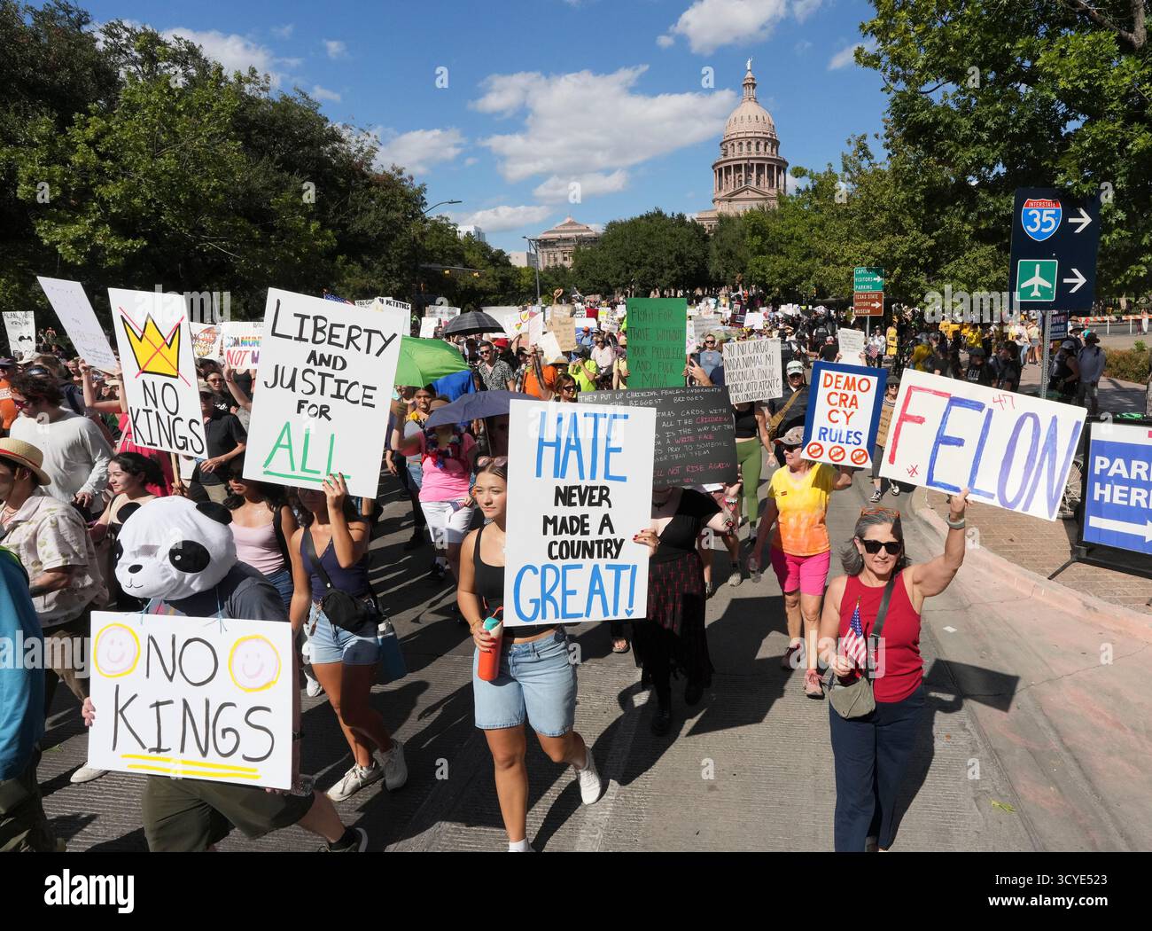 Austin Texas USA, 18 ottobre 2025: Migliaia di manifestanti marciano lungo Congress Avenue durante la manifestazione di protesta "No Kings" contro l'amministrazione del presidente Donald Trump. Greg Abbott, capo del Texas, ha minacciato un lancio della Guardia Nazionale del Texas contro quella che era una protesta ampiamente pacifica monitorata dalla polizia locale. Crediti: Bob Daemmrich/Alamy Live News Foto Stock