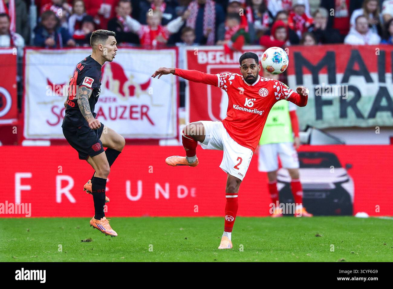 Mainz, Germania. 18 ottobre 2025. Phillipp Mwene (R) della FSV Mainz 05 vies con Alejandro Grimaldo del Bayer 04 Leverkusen durante la partita di calcio tedesca di prima divisione tra FSV Mainz 05 e Bayer 04 Leverkusen a Magonza, Germania, 18 ottobre 2025. Crediti: Joachim Bywaletz/Xinhua/Alamy Live News Foto Stock