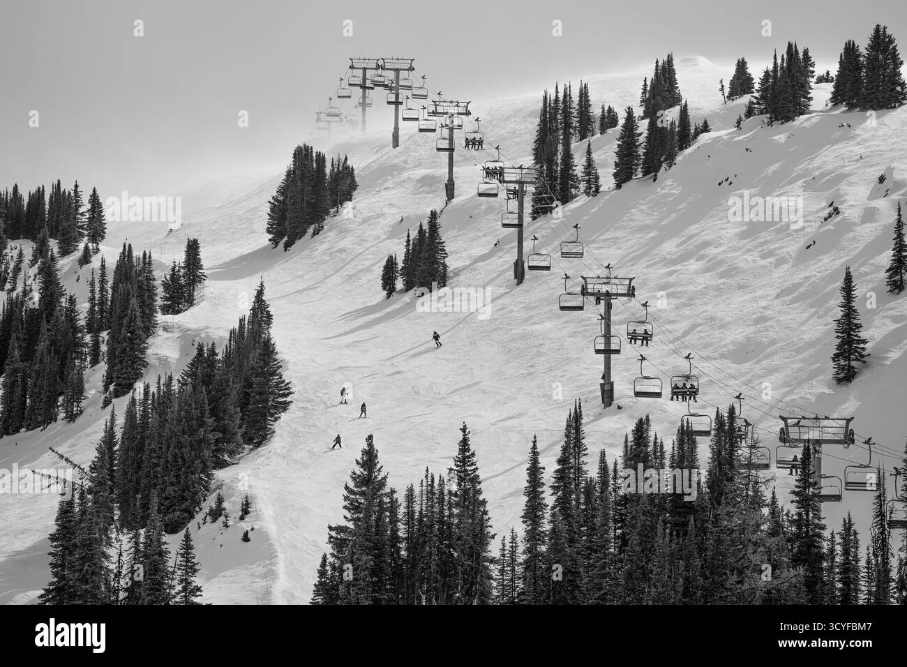 Sciatori e snowboarder in sella alla seggiovia Standish presso la stazione sciistica Sunshine Village di Banff, Alberta Foto Stock