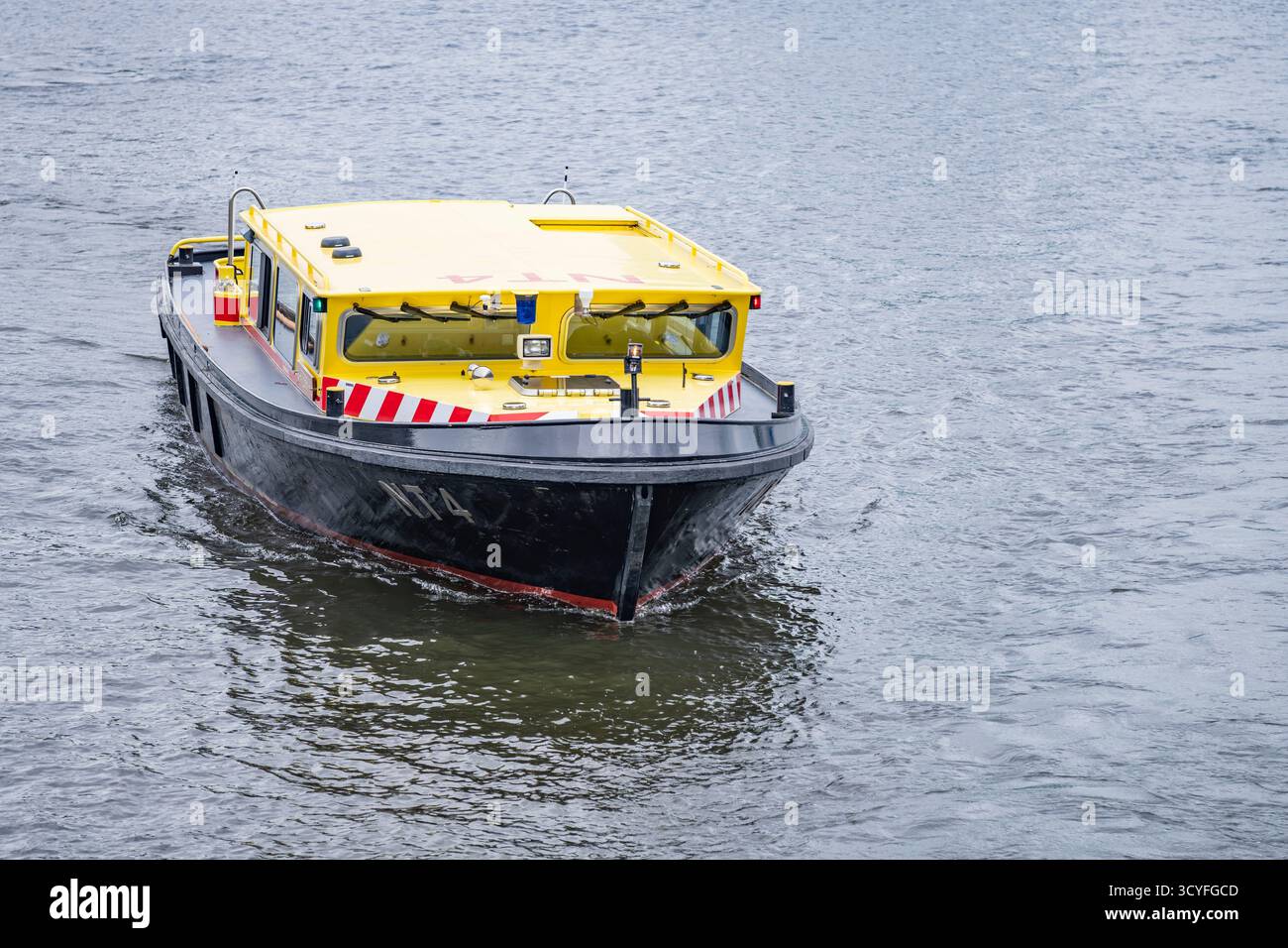Piccola barca nera e gialla in barca a vela sul fiume Amstel ad Amsterdam - Vista frontale Foto Stock