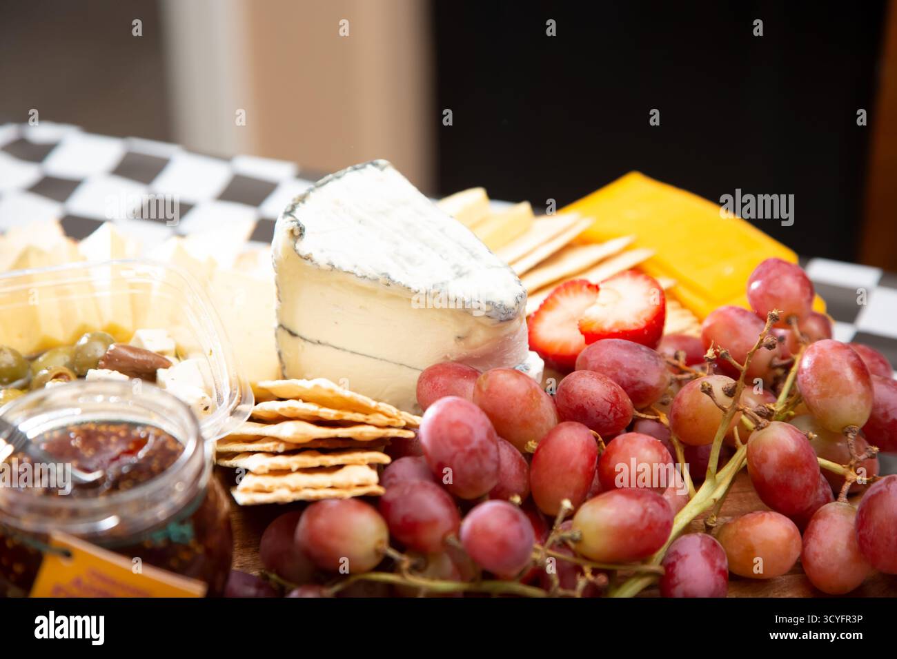 Vista su un tagliere di formaggi assortiti, con un pezzo di brie. Foto Stock