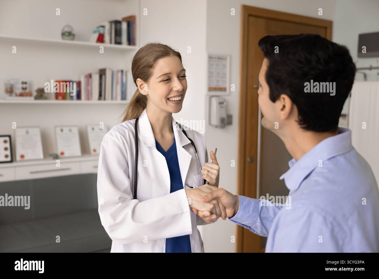 Medico specialista in medicina generale con mani agitate uniformi con paziente di sesso maschile Foto Stock