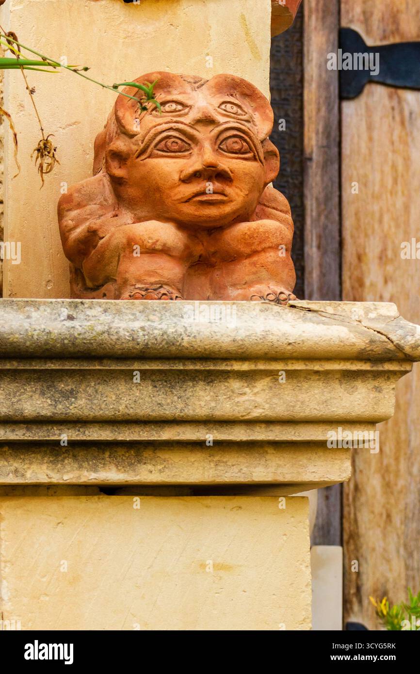 Statua Gargoyle in terracotta ornamento su architettura con balcone in pietra intemprata Foto Stock