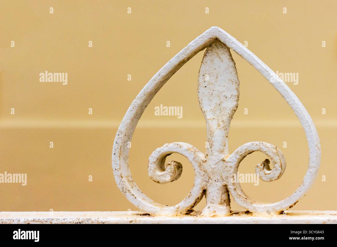 Elegante decorazione Fleur-De-Lis in ferro bianco sulla parte superiore del cancello d'epoca per un arredamento classico Foto Stock