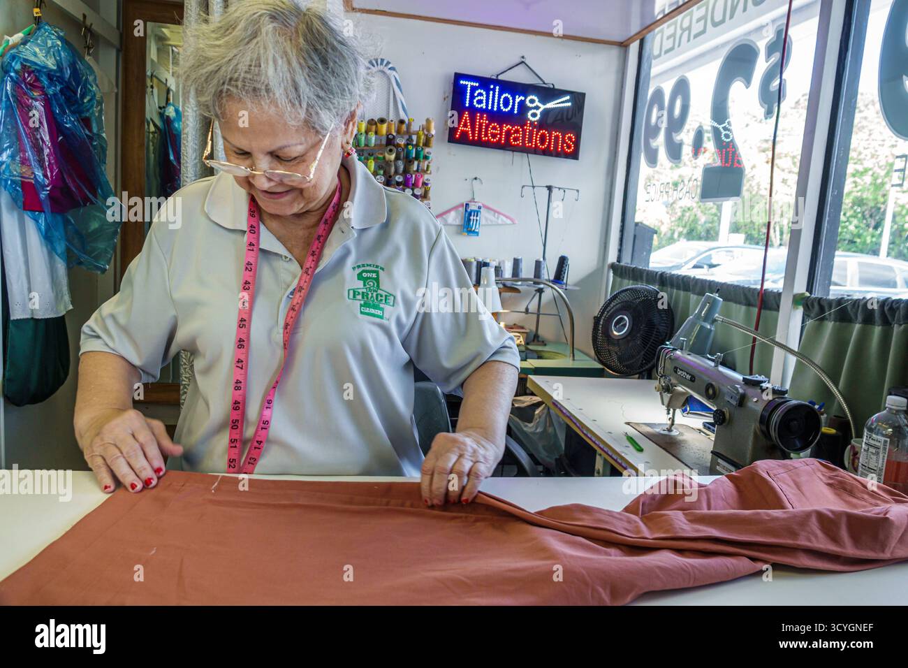 Miami Florida, affari su Biscayne Boulevard, negozio di modifiche sartoriali all'interno degli interni, donna anziana ispanica, adulto, con metro a nastro e tessuto Foto Stock