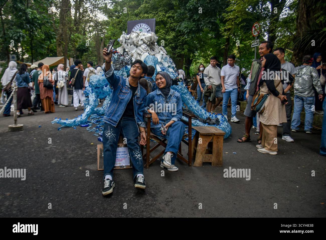 Bandung, Giava Occidentale, Indonesia. 19 ottobre 2025. I visitatori fanno un selfie davanti alle installazioni artistiche presso l'ITB Art Market del Bandung Institute of Technology. L'ITB Art Market, ospitato dalla Facoltà di Belle Arti e Design del Bandung Institute of Technology (ITB), presenta 257 inquilini che espongono opere d'arte, delizie culinarie e installazioni creative. L'evento mira ad ampliare l'apprezzamento del pubblico per l'arte e funge da piattaforma per la collaborazione tra artisti, designer, musicisti e il pubblico. (Credit Image: © Dimas Rachmatsyah/ZUMA Press Wire) SOLO PER USO EDITORIALE! Non per Co Foto Stock