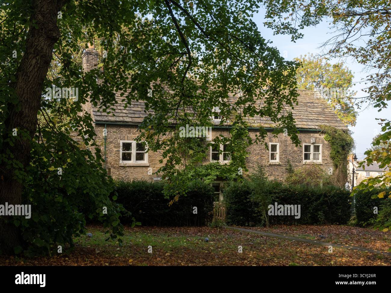 Tradizionale cottage in pietra circondato da alberi autunnali a Wentworth, South Yorkshire, Inghilterra. Foto Stock