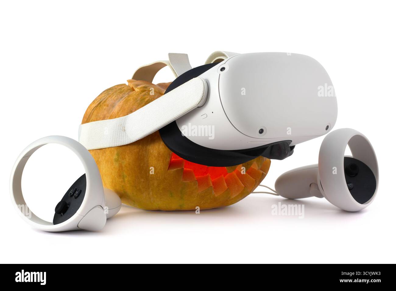 Zucca intagliata con un sorriso, illuminata dall'interno da un bagliore arancione, che funge da jack-o'-lanterna di Halloween, indossando una realtà virtuale (VR) h. Foto Stock