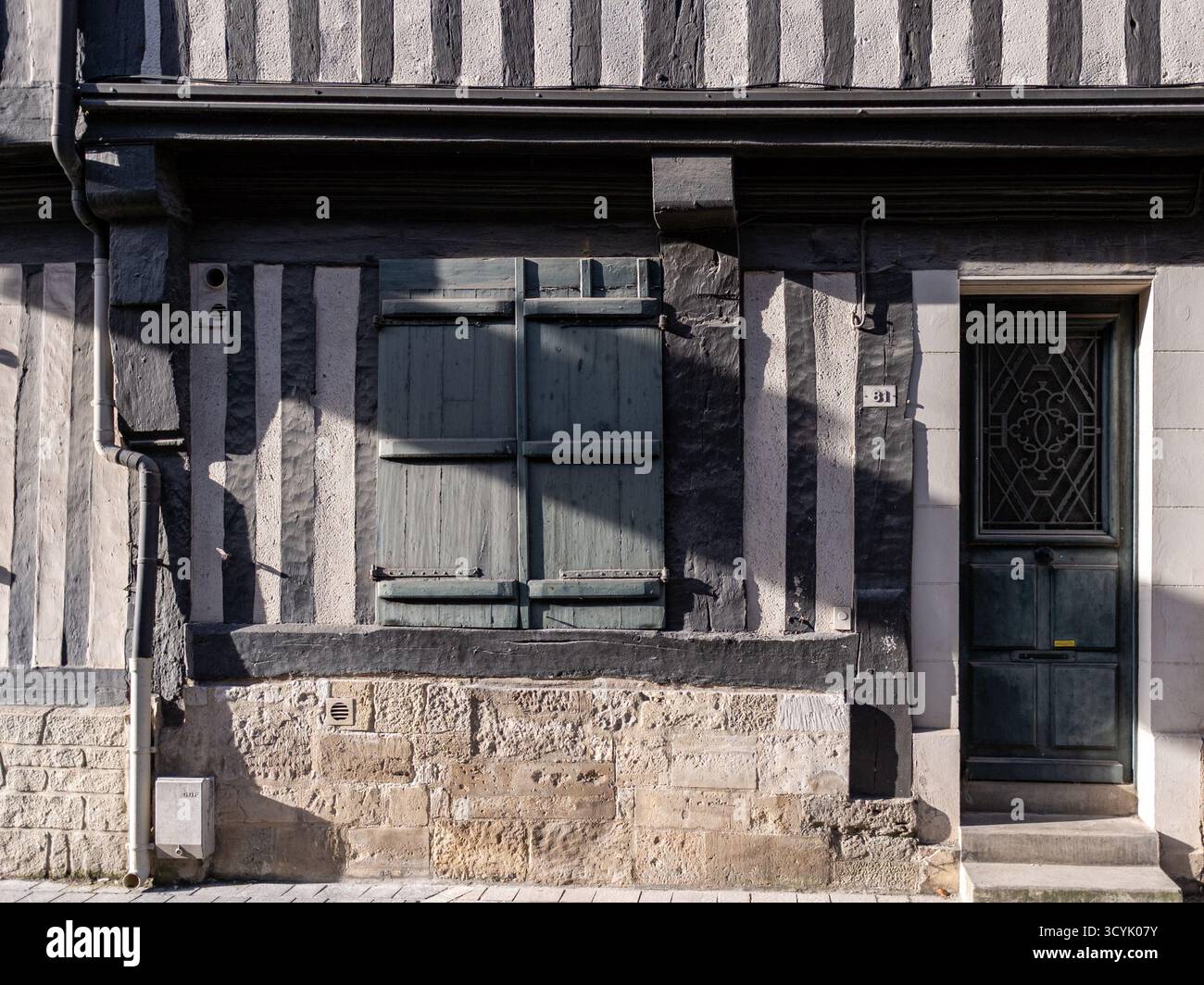 Facciata della tradizionale casa cittadina in legno a Honfleur, Francia. Preso in una soleggiata mattinata d'autunno senza gente Foto Stock