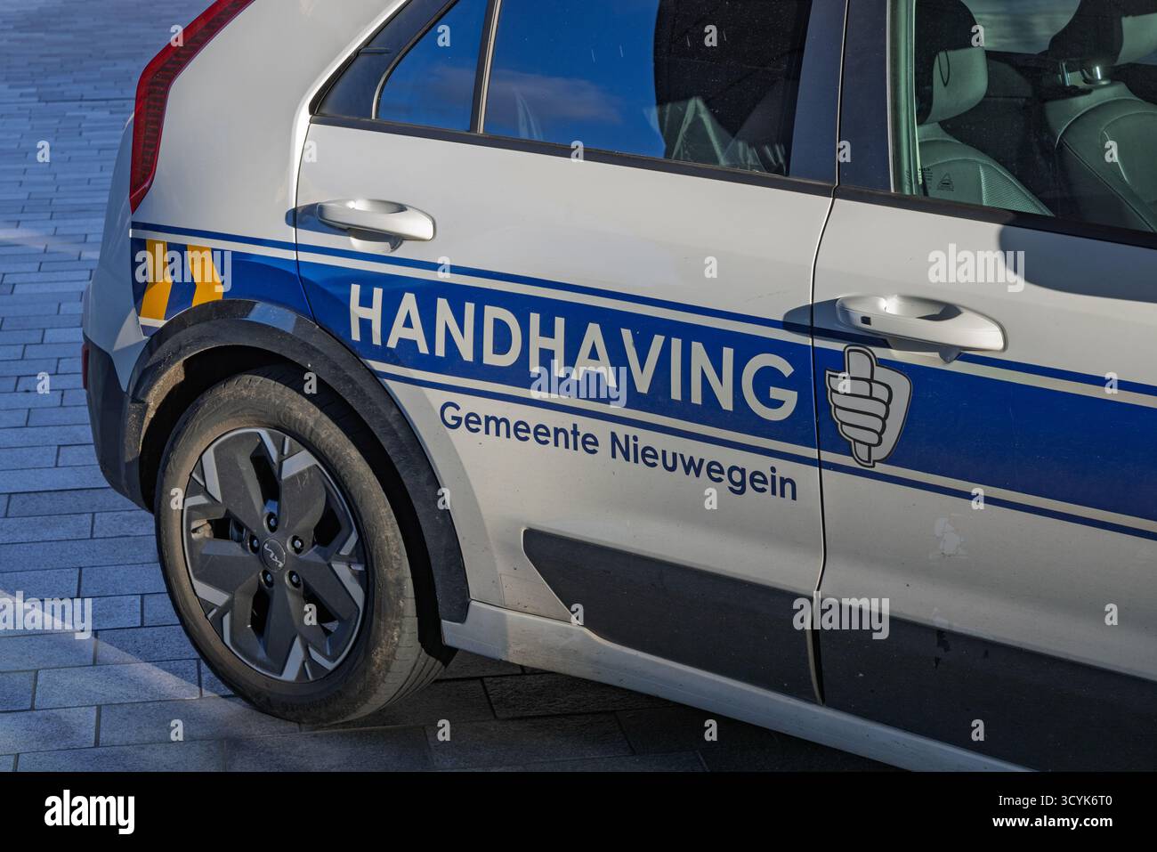 Vista laterale di un veicolo "Handhaving" dal comune di Nieuwegein, con le sue distinte strisce blu e gialle, che indicano la pubblica sicurezza e l Foto Stock