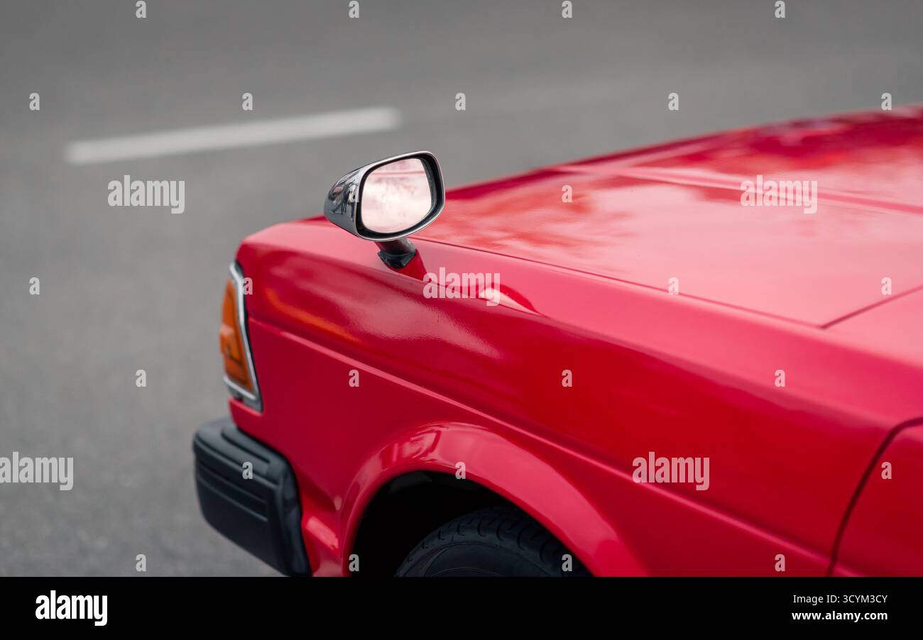 Auto giapponese rossa anni '1980 con specchietti retrovisori. Parte anteriore laterale della vecchia vettura JDM - vista dal retro. Foto Stock Auto giapponese rossa anni '1980 con specchietti retrovisori. Parte anteriore laterale della vecchia vettura JDM - vista dal retro. Foto Stock