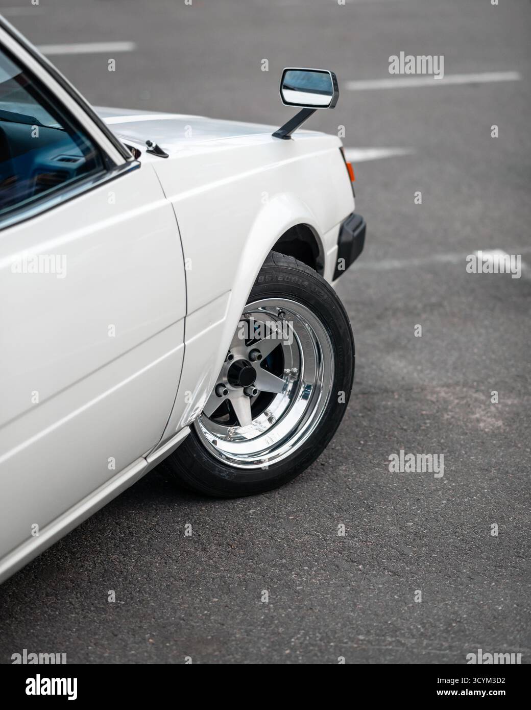 Vecchia auto giapponese bianca degli anni '1980 con specchietti retrovisori. Parte laterale della vettura JDM - vista dal retro. Foto Stock Vecchia auto giapponese bianca degli anni '1980 con specchietti retrovisori. Parte laterale della vettura JDM - vista dal retro. Foto Stock