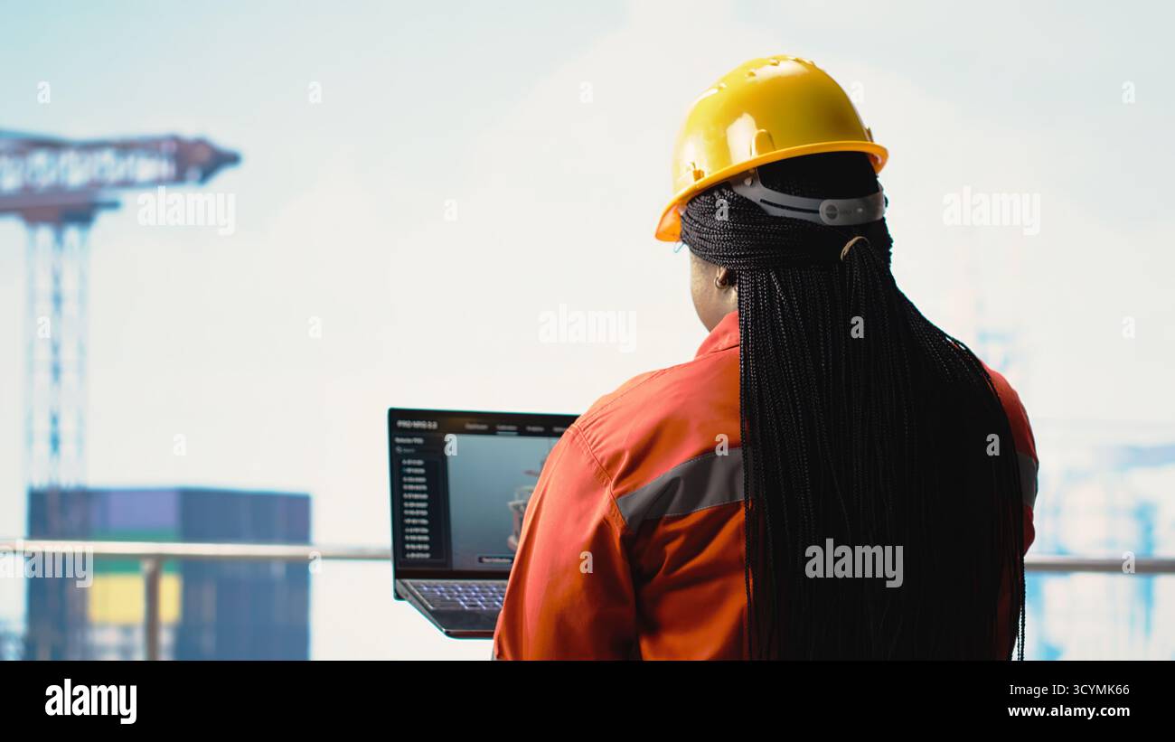 Operaio di attrezzature offshore sul ponte della piattaforma petrolifera per il monitoraggio delle operazioni con laptop software. Esperto di carri di perforazione che esamina le operazioni energetiche utilizzando un notebook, prevedendo guasti alle apparecchiature Foto Stock