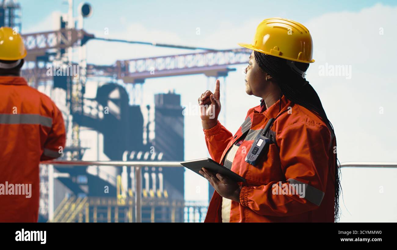 Team di ingegneri di piattaforme offshore che supervisionano l'attività di produzione sul ponte per piattaforme petrolifere. Specialisti dei carri di perforazione che coordinano le operazioni quotidiane utilizzando i dispositivi, effettuando la manutenzione Foto Stock