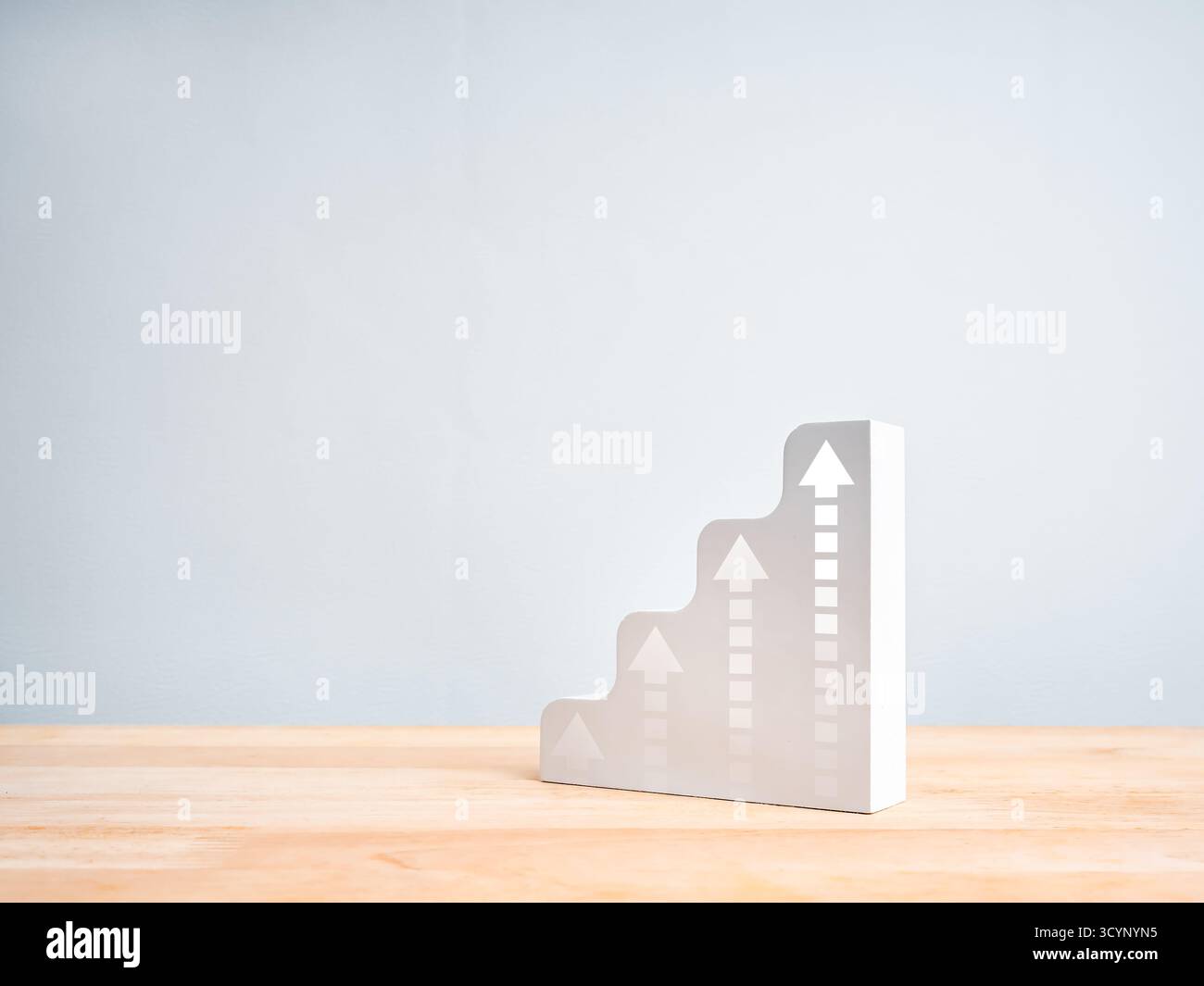 Grafico a gradini bianco 3D minimo con frecce rivolte verso l'alto su un tavolo in legno, che rappresenta il concetto di crescita aziendale, il successo finanziario, il profitto, il rendimento imp Foto Stock
