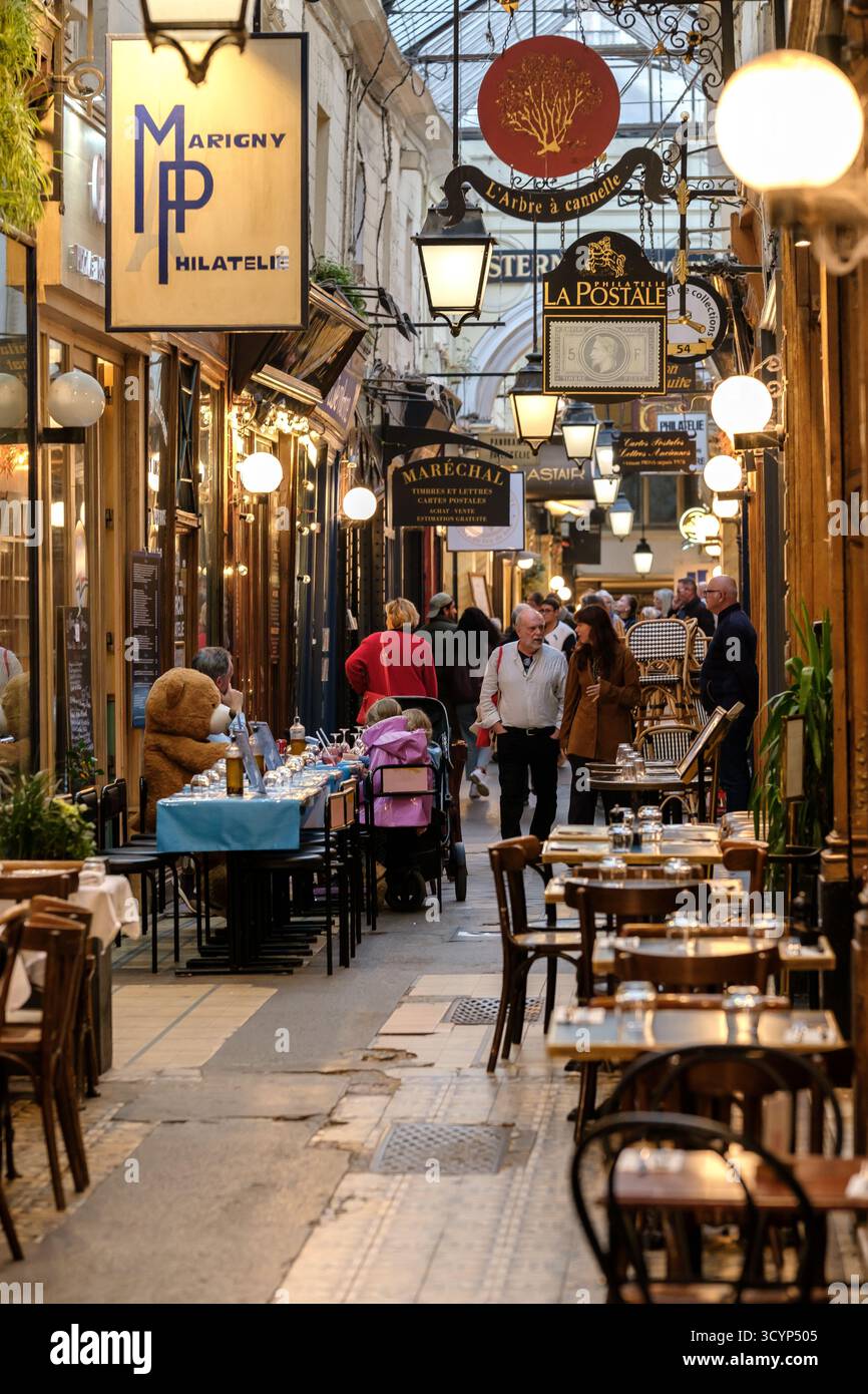 Parigi, Francia - 11 ottobre 2025: Veduta di ristoranti e persone al passaggio coperto, Passage des panoramas a Parigi Francia Foto Stock