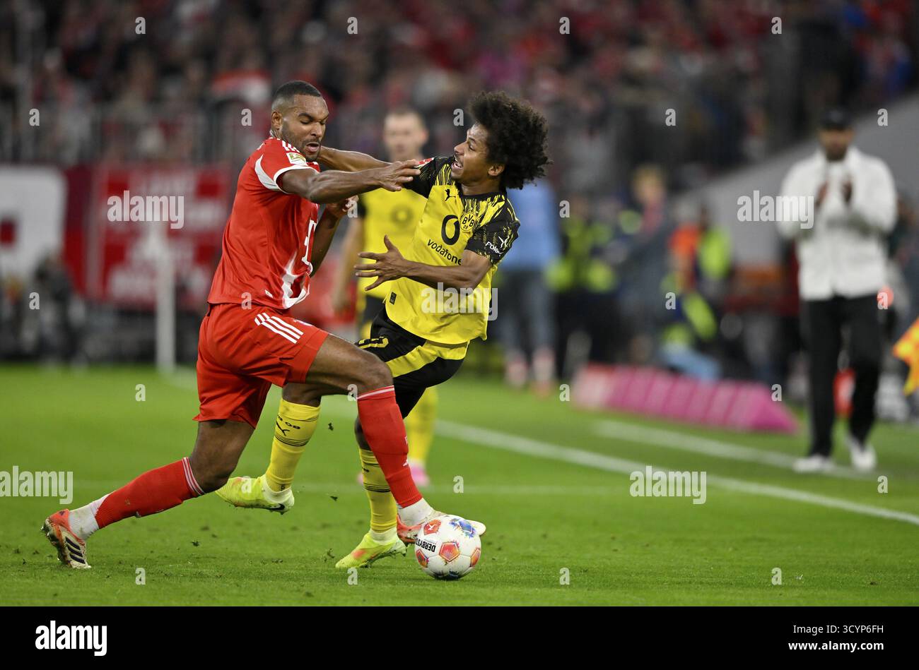 Duello, azione Jonathan Tah FC Bayern Monaco FCB (04) contro Karim Adeyemi Borussia Dortmund BVB (27) allenatore Vincent Kompany FC Bayern Monaco FCB claps Foto Stock