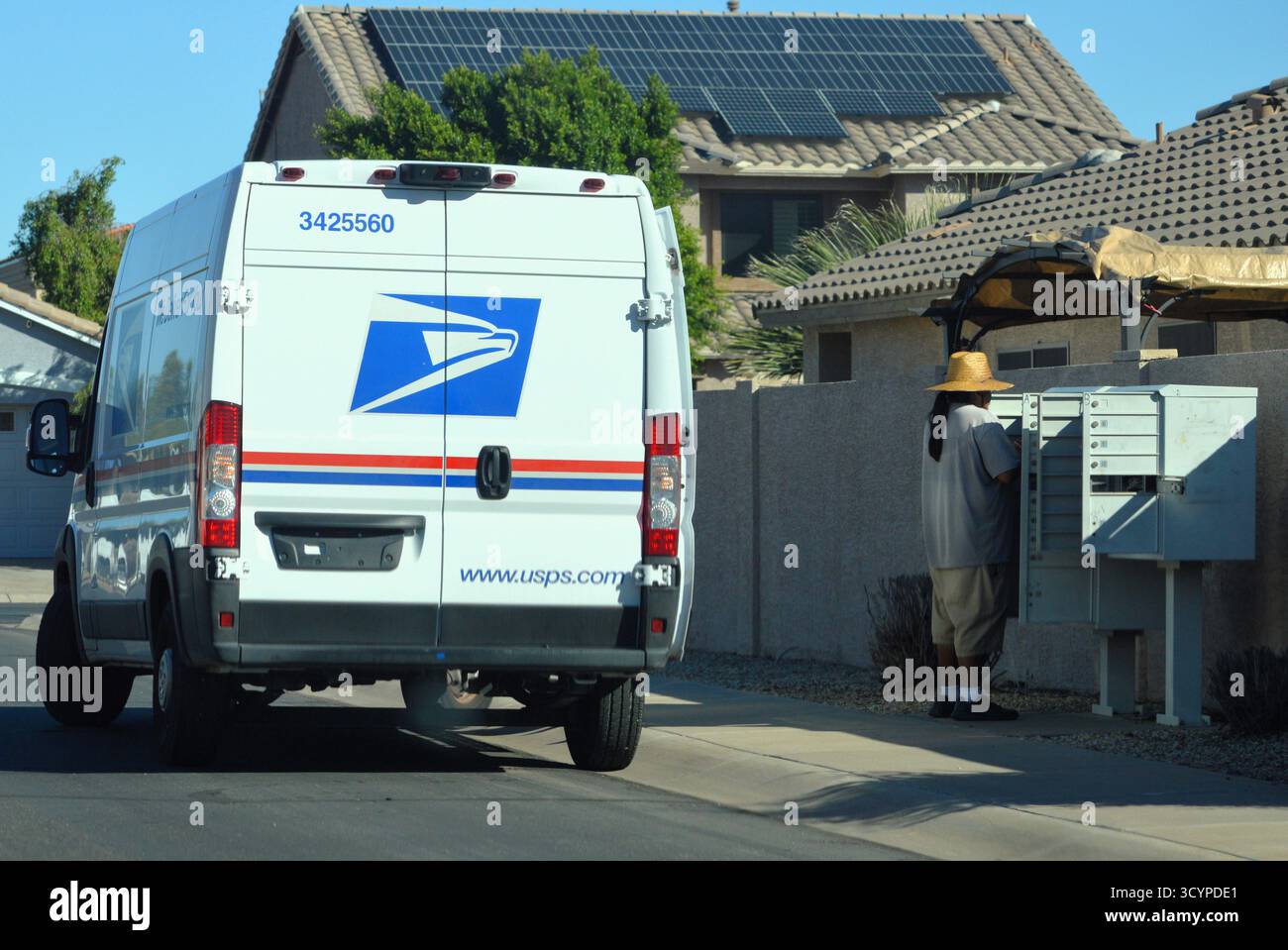 L'addetto postale USPS e il camion consegnano la posta a una cassetta postale del quartiere in Arizona Foto Stock