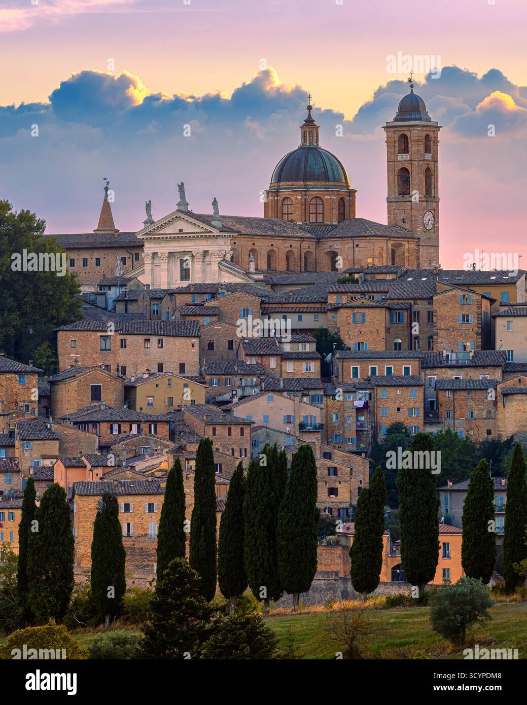 Vista verticale di Urbino, Marche, Italia, al tramonto. Lo storico skyline rinascimentale emette una calda luce naturale, senza alcuna illuminazione artificiale Foto Stock