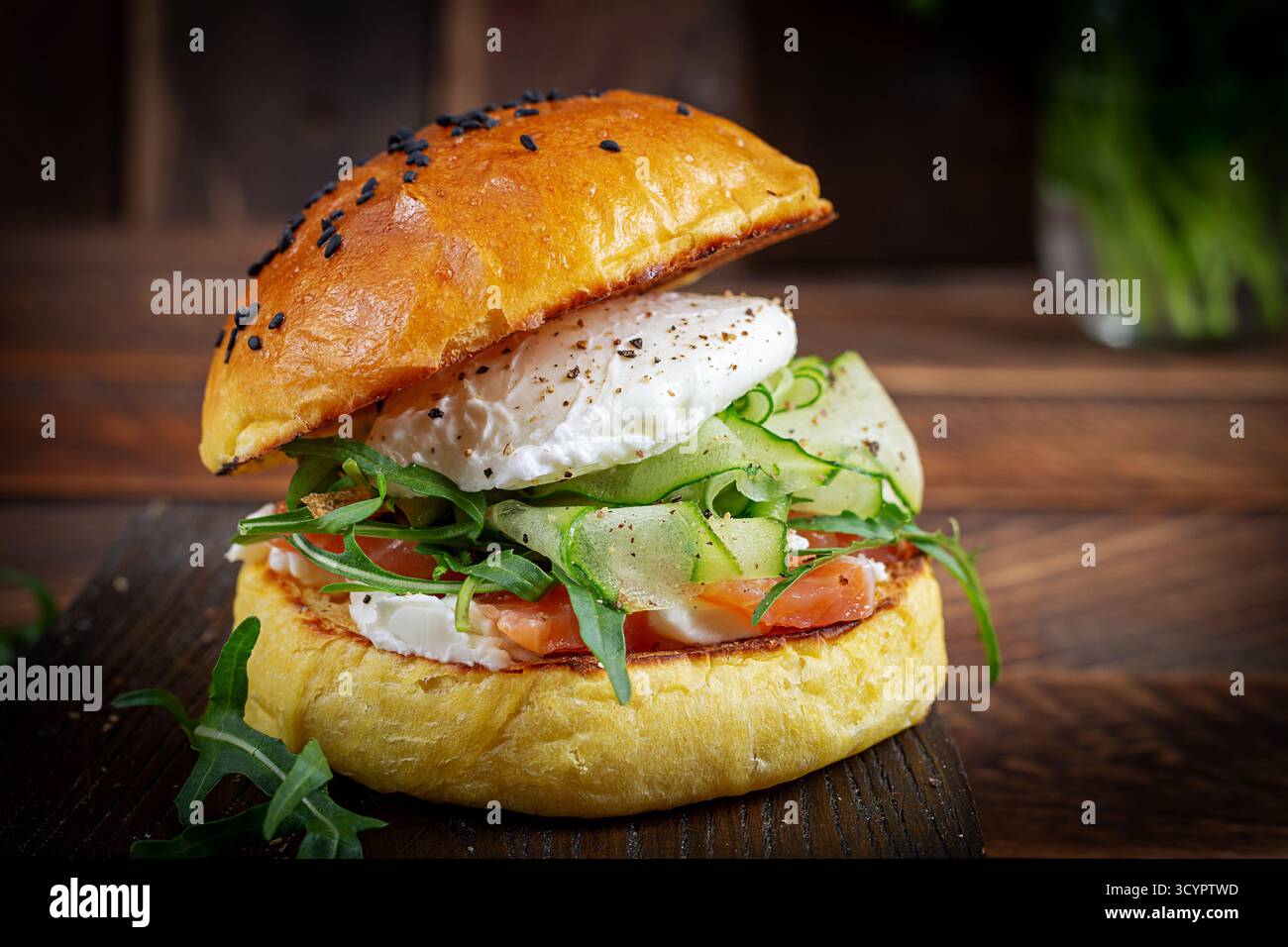 Panino per colazione con salmone salato, formaggio spalmabile e uova in camicia Foto Stock