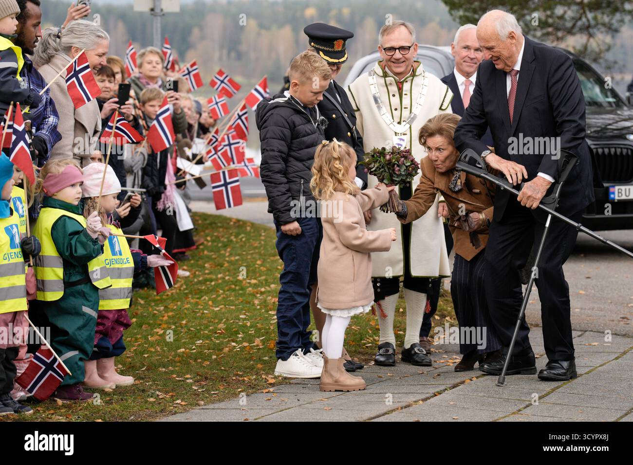 Aremark 20251020. Re Harald e la regina Sonja ricevono fiori da Ingrid Cornelia Sydnes, 4 anni (asilo Aremark) e Emil Oliver Vestby, 9 anni, quarta elementare (scuola Aremark) durante una visita al comune di Aremark nella contea di Ostfold. Dietro di loro ci sono l'amministratore di Stato Jan Tore Sanner, il sindaco Haakon Tolsby e il capo della polizia Cecilie Lilaas-Skari. Foto: Stian Lysberg Solum / NTB questo testo è tradotto automaticamente Foto Stock