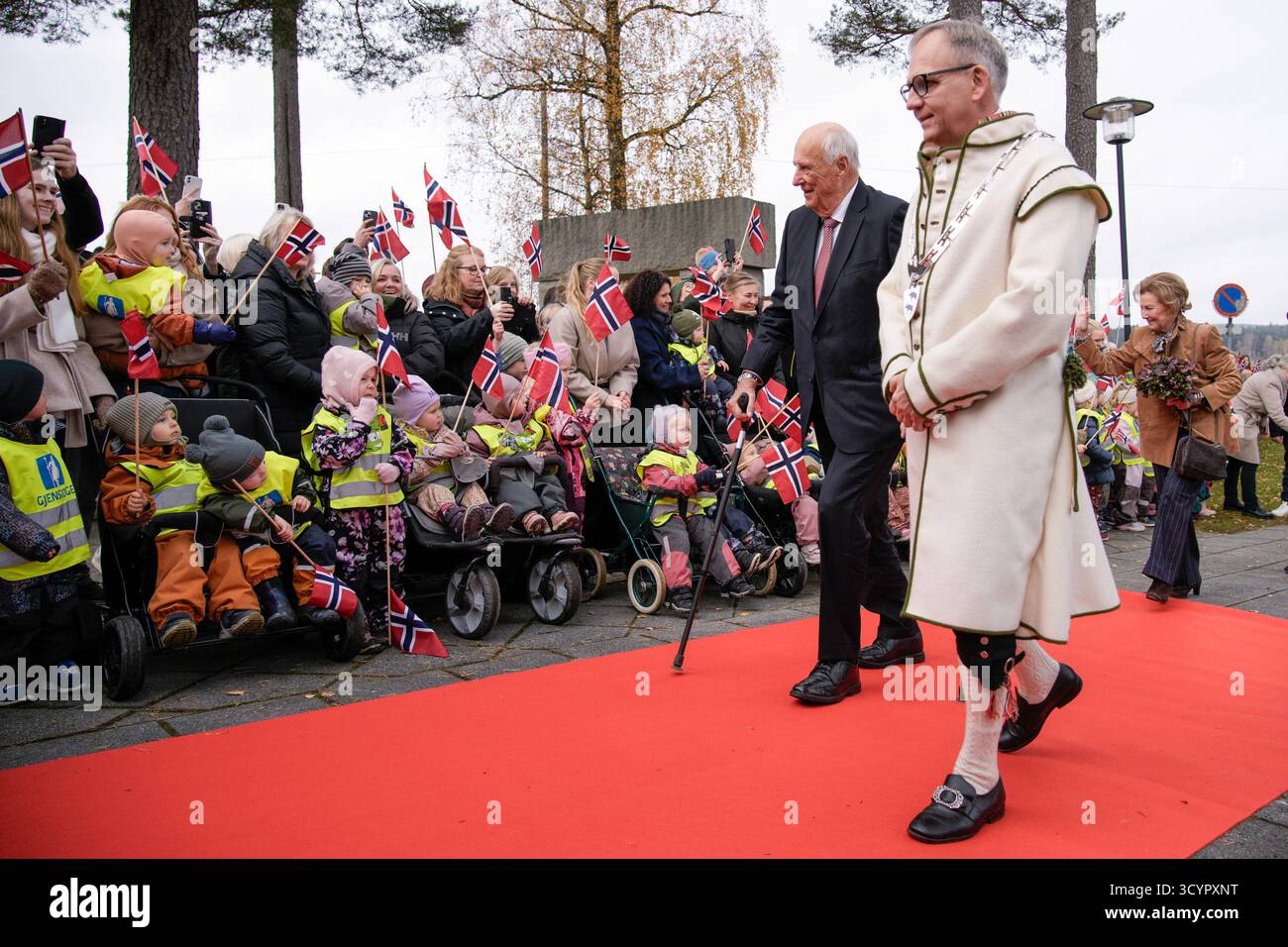 Aremark 20251020. Re Harald, la regina Sonja e il sindaco Haakon Tolsby salutano i bambini e i residenti dell'asilo durante una visita al comune di Aremark nella contea di Østfold. Foto: Stian Lysberg Solum / NTB questo testo è tradotto automaticamente Foto Stock
