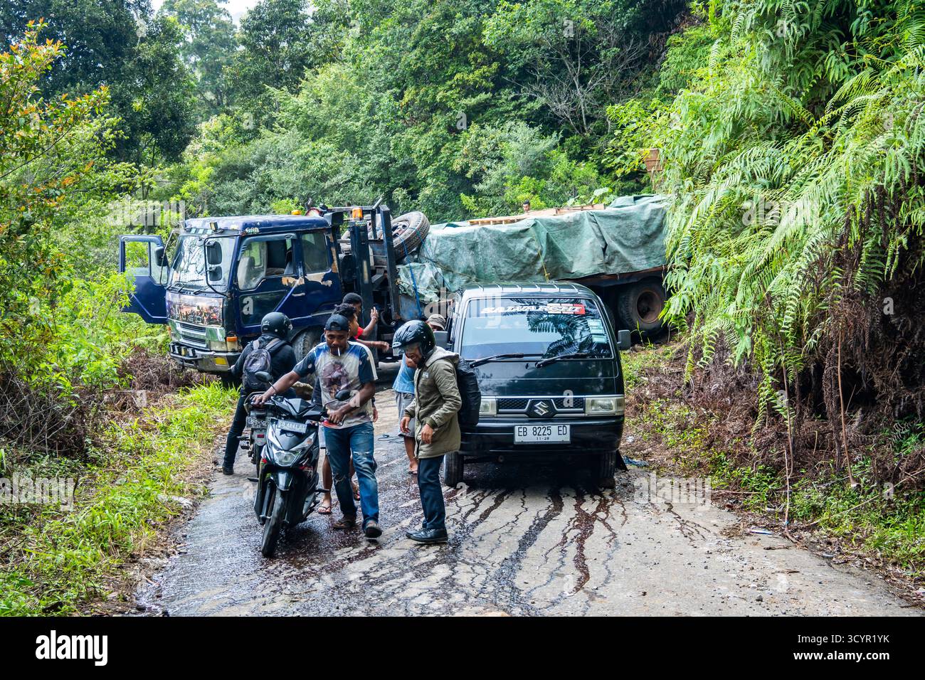 Incidente stradale, un camion che esce dalla strada di montagna e blocca tutto il traffico. Isola di Flores, Indonesia. Foto Stock