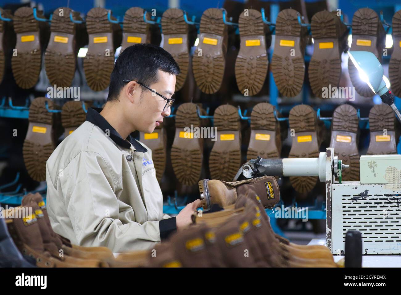 Pechino, la provincia cinese di Shandong. 20 ottobre 2025. Un dipendente lavora una scarpa in un'azienda di Gaomi City, nella provincia di Shandong, nella Cina orientale, 20 ottobre 2025. Il prodotto interno lordo (PIL) della Cina è cresciuto del 5,2% su base annua nei primi tre trimestri del 2025, i dati dell'Ufficio nazionale di statistica (NBS) hanno mostrato lunedì. Crediti: Li Haitao/Xinhua/Alamy Live News Foto Stock