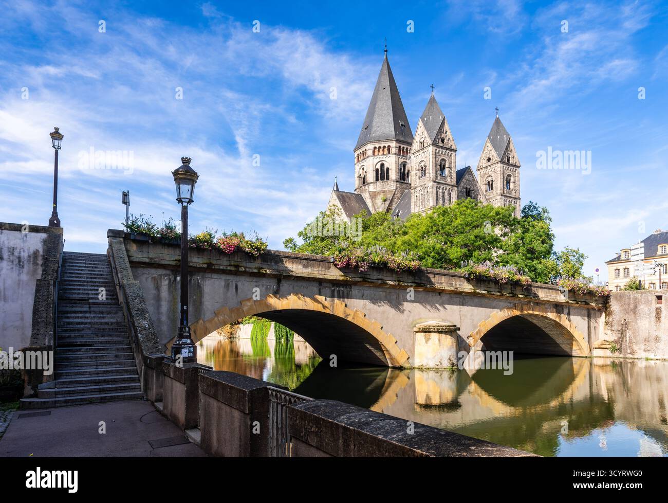 Vista del Pont des Roches a Metz, in Francia, un ponte in pietra sul fiume Mosella, con la chiesa protestante Temple Neuf sull'isola di Petit-Saulcy Foto Stock