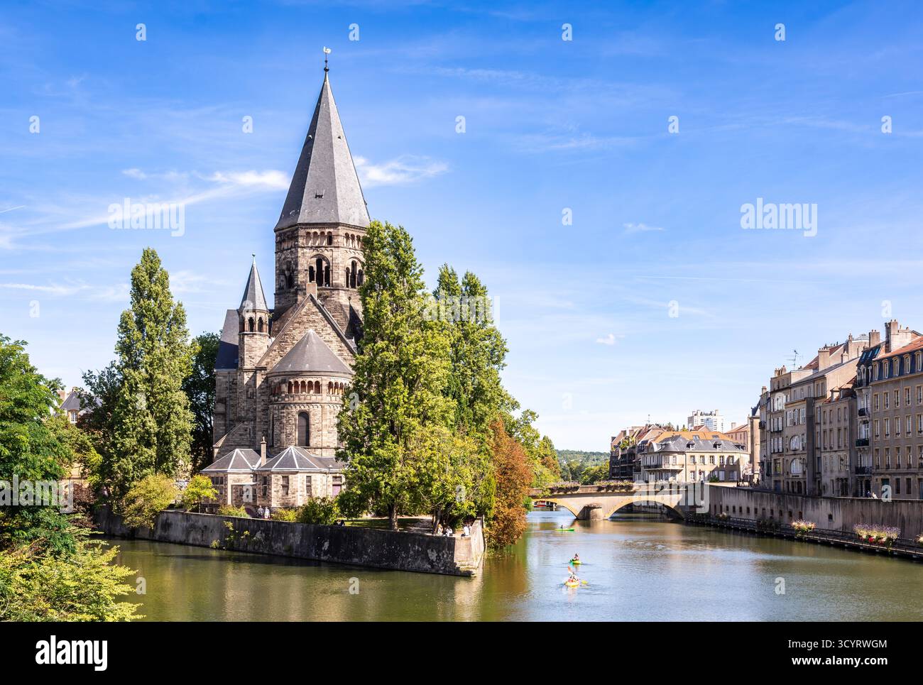 Metz, Francia - 6 settembre 2025: Paesaggio urbano con il Tempio di Neuf, una chiesa protestante costruita nel 1905 sull'isola di Petit-Saulcy, e turisti kayaki Foto Stock