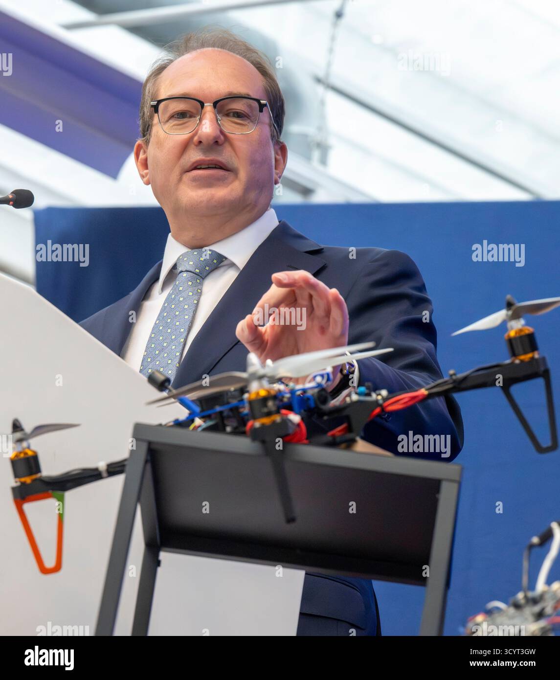 Monaco, Germania. 20 ottobre 2025. Il ministro federale dell'interno Alexander Dobrindt (CSU) si trova dietro un drone autocostruito FPV con caratteristiche speciali durante la sua visita presso l'Ufficio centrale per le tecnologie dell'informazione nel settore della sicurezza (ZITiS). L'argomento della visita riguardava le attuali sfide in materia di sicurezza, in particolare nel contesto dei droni. Crediti: Peter Kneffel/dpa/Alamy Live News Foto Stock