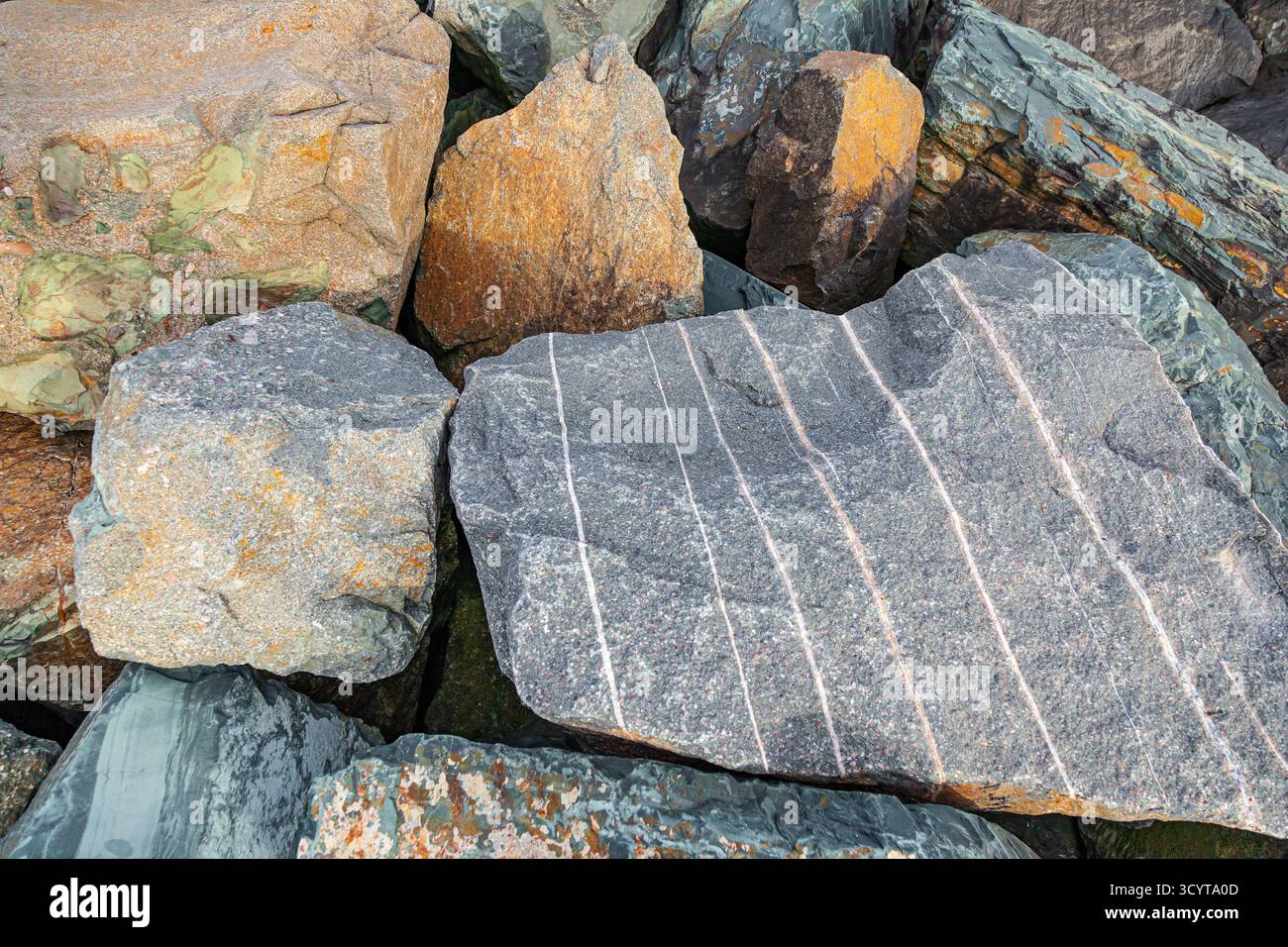 Un mucchio di enormi pietre multicolore giace l'una accanto all'altra Foto Stock