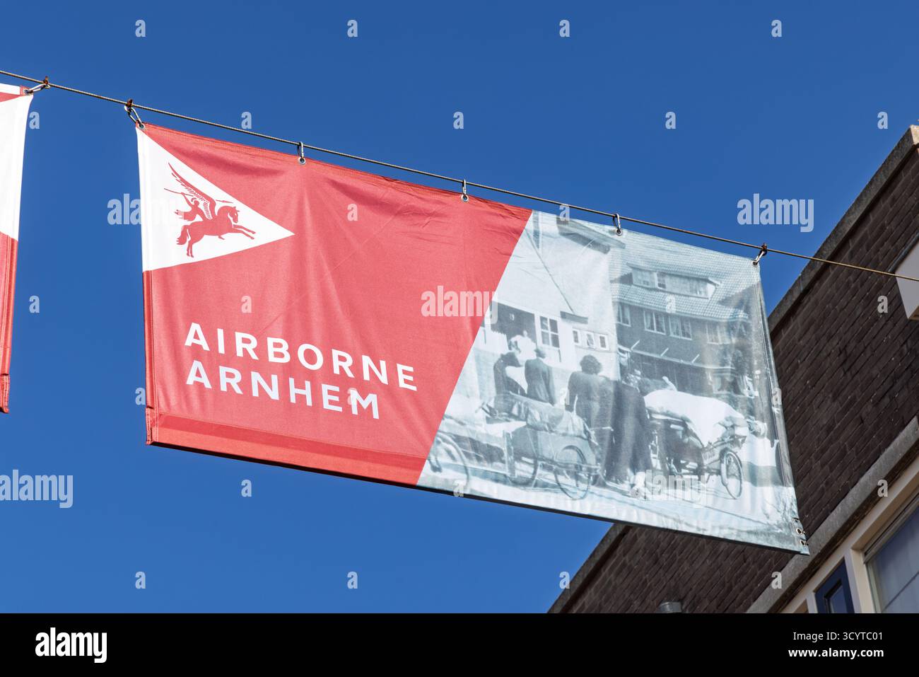 Una bandiera esposta ad Arnhem per commemorare l'operazione aviotrasportata, che mostra il simbolo Pegasus e una foto storica in bianco e nero. Foto Stock