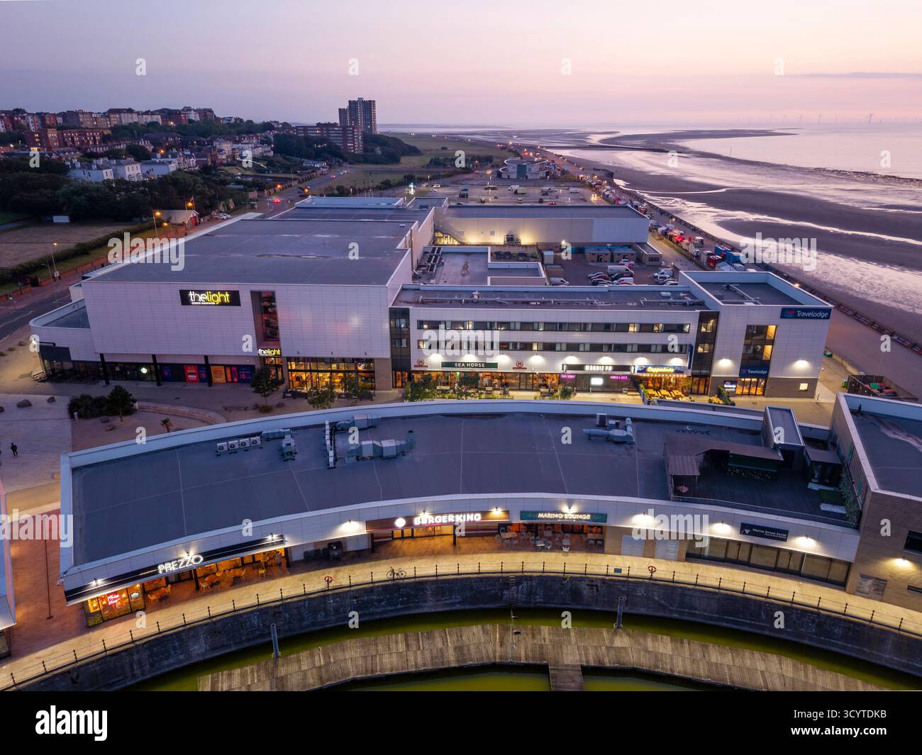 WIRRAL, MERSEYSIDE, INGHILTERRA - 13 AGOSTO 2025: Immagine al tramonto del parco divertimenti e dei negozi di Marine Point a New Brighton, Wirral, Inghilterra, che mostra la modalità Foto Stock