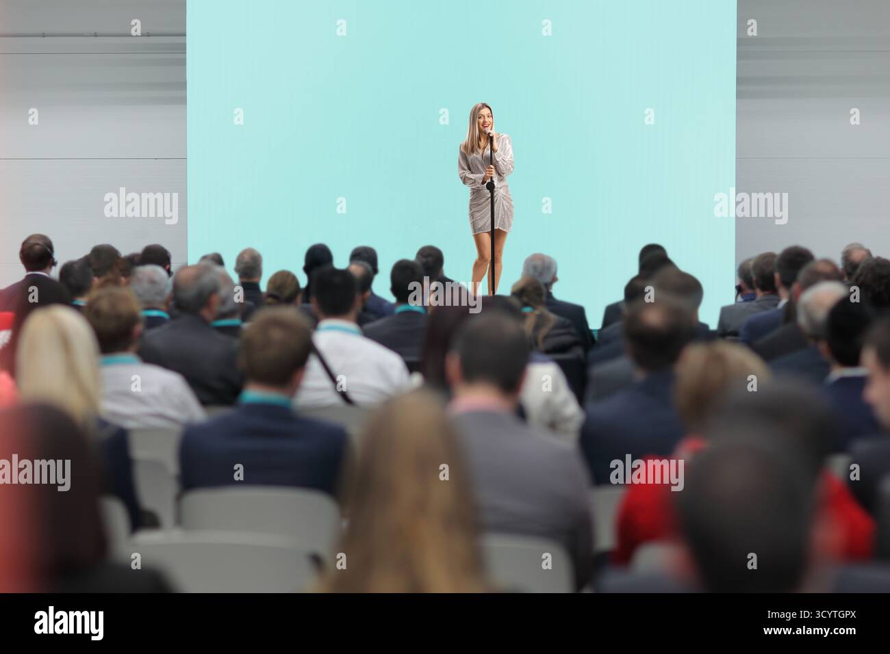 Cantante femminile sul palco che canta davanti a persone nel pubblico Foto Stock
