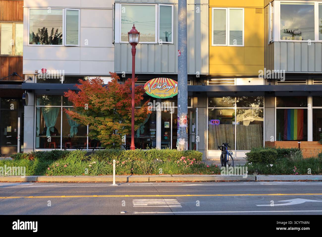 Esterno del ristorante Jade Garden in Beacon Avenue South a Seattle, Washington al tramonto. Albero d'acero, bandiera arcobaleno e vista stradale in autunno. Foto Stock