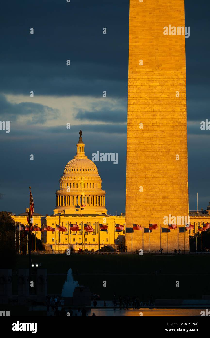 Il Campidoglio DEGLI STATI UNITI e il Washington Monument National Mall Washington DC // WASHINGTON DC - il Washington Monument e il Campidoglio degli Stati Uniti sono illuminati dalla luce dorata del sole appena prima del tramonto sul National Mall. Il 29 Washington Monument alto 169 metri (555 piedi) è un iconico obelisco in onore di George Washington, il primo presidente degli Stati Uniti. Il Campidoglio degli Stati Uniti, con la sua caratteristica cupola, ospita il Congresso degli Stati Uniti. Queste principali attrazioni si trovano sul National Mall nel centro di Washington DC. Le bandiere americane volano in modo prominente davanti al Campidoglio, riflettendo la capitale della nazione. Foto Stock