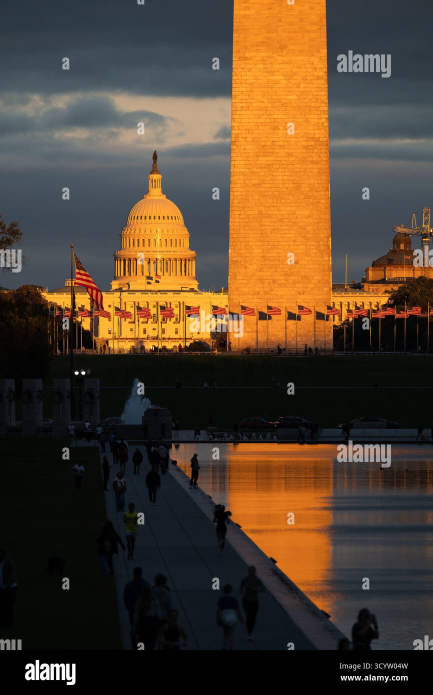 Il Campidoglio DEGLI STATI UNITI e il Washington Monument National Mall Washington DC // WASHINGTON DC - il Monumento a Washington e il Campidoglio degli Stati Uniti sono illuminati dalla luce dorata del tramonto sul National Mall. Il Monumento a Washington, un obelisco in onore di George Washington, è alto 169,29 metri (555 piedi e 5 pollici). Il Campidoglio degli Stati Uniti, sormontato dalla sua iconica cupola, è la sede del Congresso degli Stati Uniti. Questi importanti punti di riferimento si trovano sul National Mall, un importante parco nazionale della città. La piscina arcobaleno del World War II Memorial è visibile in primo piano. Foto Stock