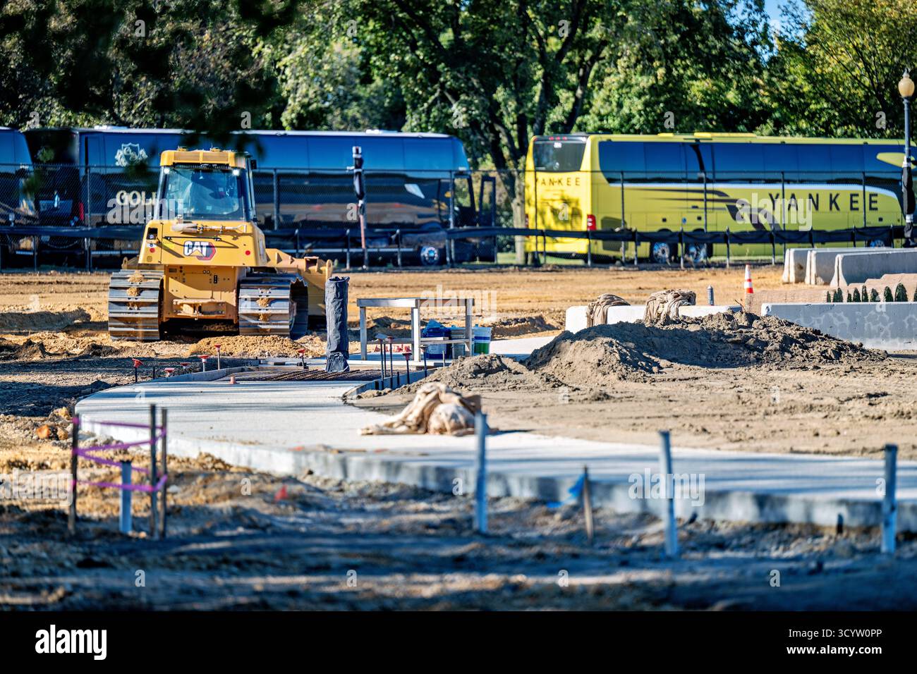 Tidal Basin Seawall Construction Project Washington DC // WASHINGTON DC — i progressi nel Tidal Basin Seawall Construction Project sono visibili il 17 ottobre 2025, mostrando un bulldozer e un percorso in cemento appena posato. Questa vista viene catturata accanto al Jefferson Memorial, guardando attraverso il bacino di marea verso l'Inlet Bridge. L'ampio progetto prevede la riparazione e l'innalzamento dei fondali marini che si deteriorano intorno al bacino delle Tidal. Questo importante lavoro infrastrutturale mira a mitigare le frequenti inondazioni causate dalle alte maree e dall'innalzamento del livello del mare, proteggendo i monumenti e i ciliegi iconici della zona. Foto Stock