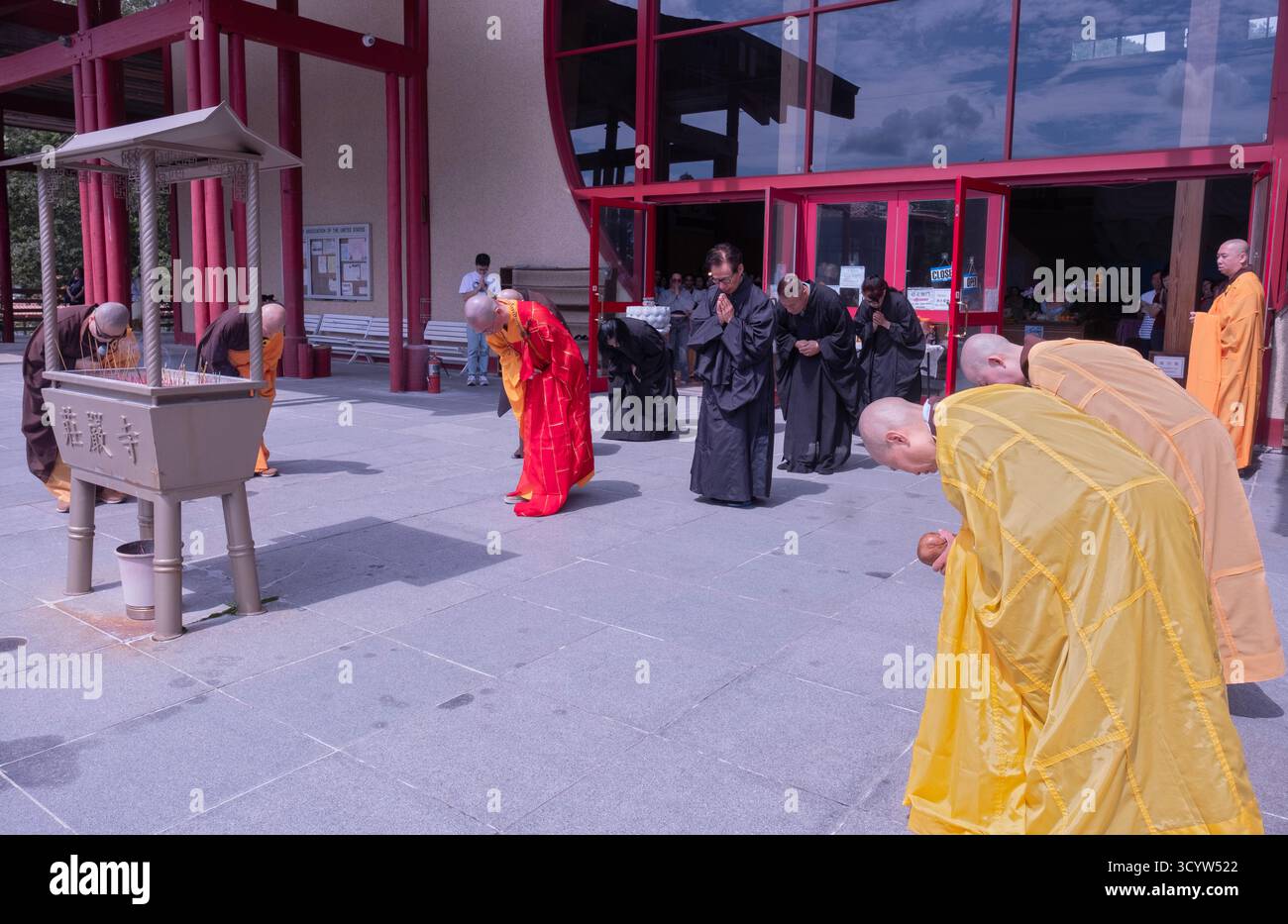 I monaci e le monache buddiste si inchinano prima di bruciare i soldi del cielo in un servizio di Ullambana che onora e benedice i defunti nell'aldilà. Foto Stock