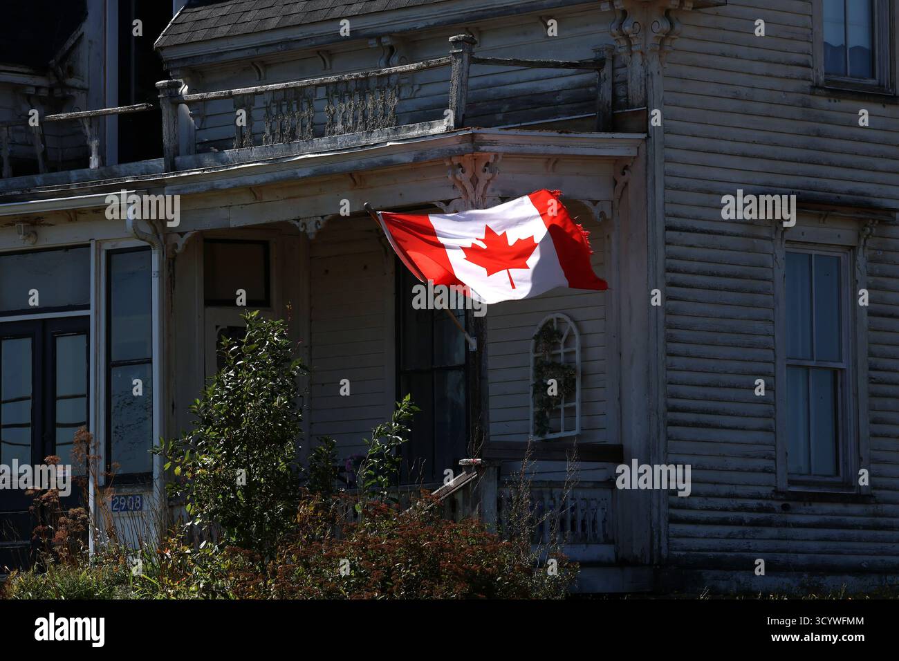 Bandiera canadese sulla vecchia casa di legno alla luce del giorno Foto Stock